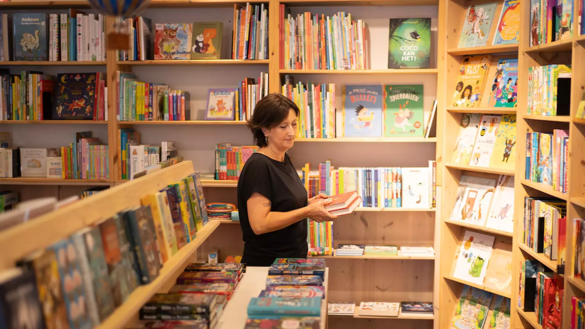 Een bezoeker in de winkel die een boek vast heeft