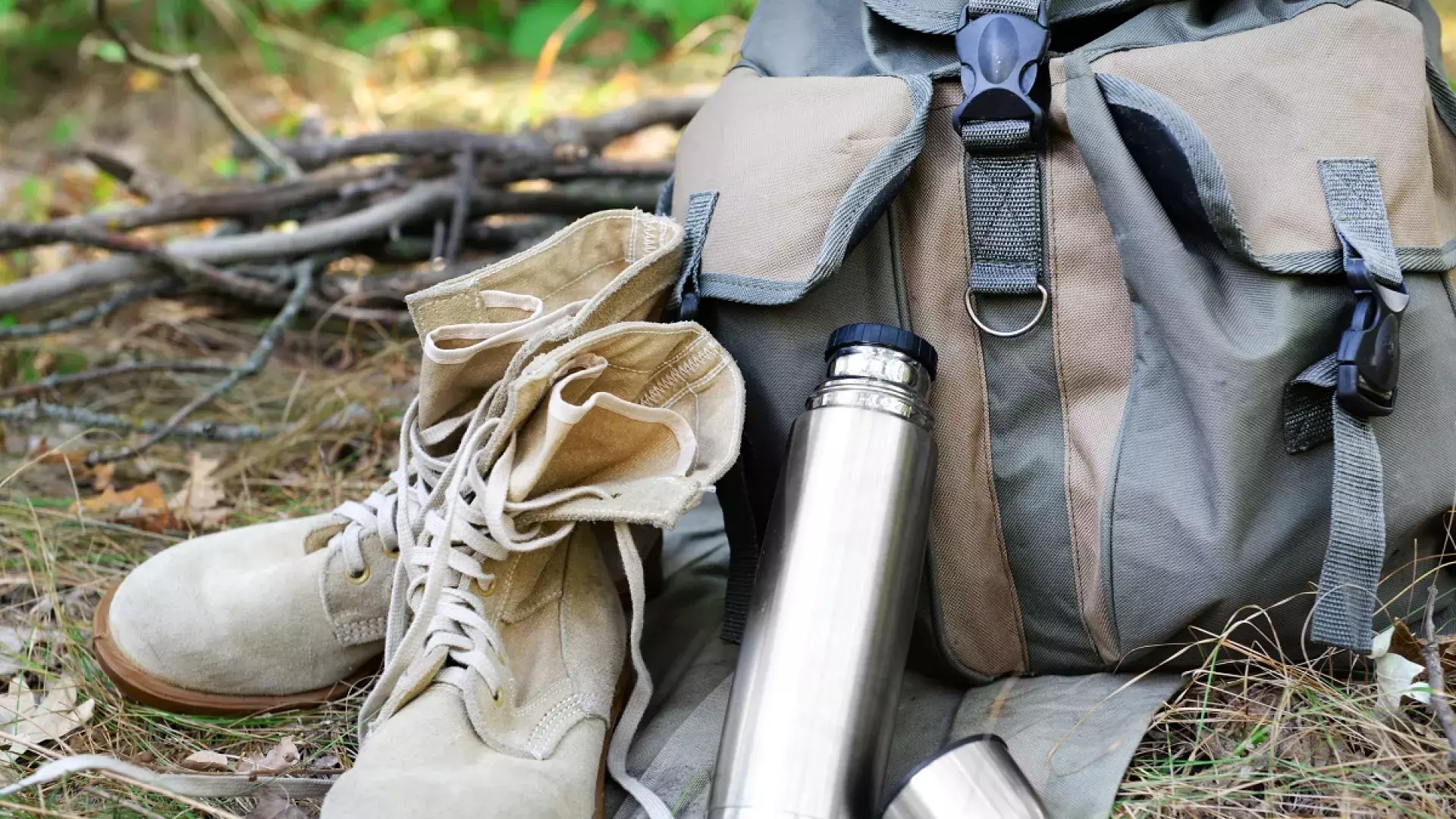 Schoenen, drinkfles en rugzak in de natuur